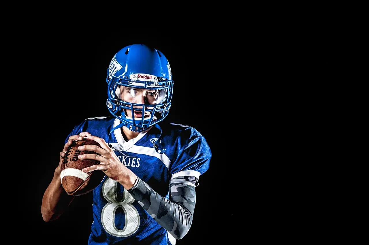 Amerikansk fodboldspiller i blå uniform holder en football